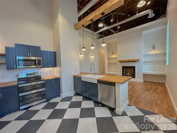 a large kitchen with stainless steel appliances a stove a sink and a refrigerator