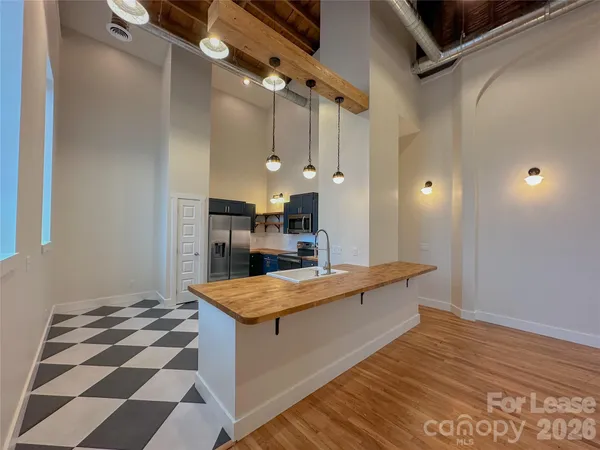 a kitchen with stainless steel appliances kitchen island granite countertop a refrigerator a stove a sink and a microwave