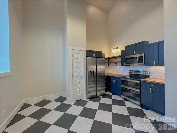 a kitchen with granite countertop stainless steel appliances and refrigerator