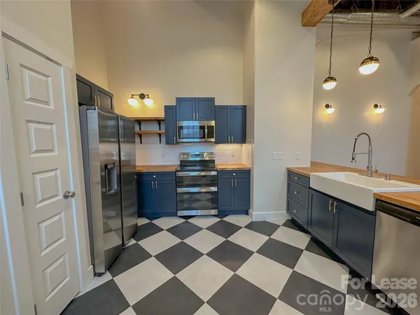 a kitchen with a sink and a stove top oven with wooden floor