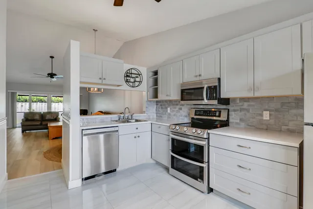 a kitchen with cabinets stainless steel appliances and a counter space