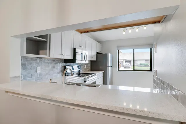 a kitchen with stainless steel appliances a microwave a sink and cabinets