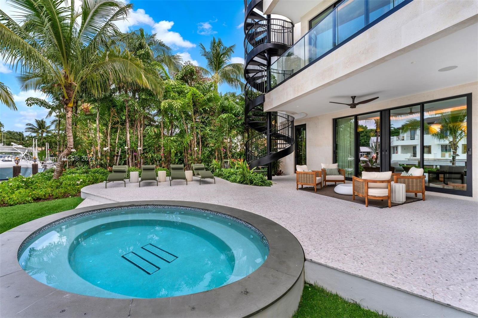 2000 North Bay Road Miami Beach, FL 33140 - Photo 55 of 62 a view of swimming pool with outdoor seating and house in the background
