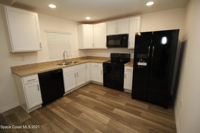 a kitchen with a sink a refrigerator and cabinets