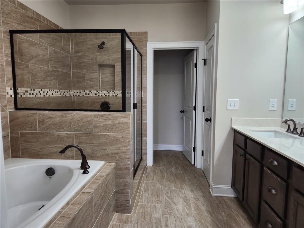 1323 Faircrest Way Suwanee, GA 30024 - Photo 12 of 16 a bathroom with a tub a sink and a large mirror