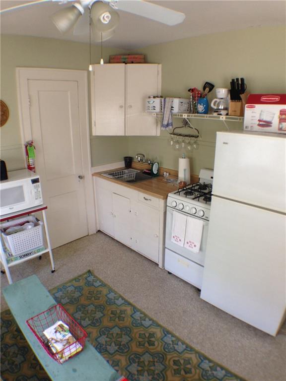 906 West 22nd Street, Unit 4 Austin, TX 78705 - Photo 4 of 6 Kitchen with white appliances, white cabinetry, a ceiling fan, and light countertops