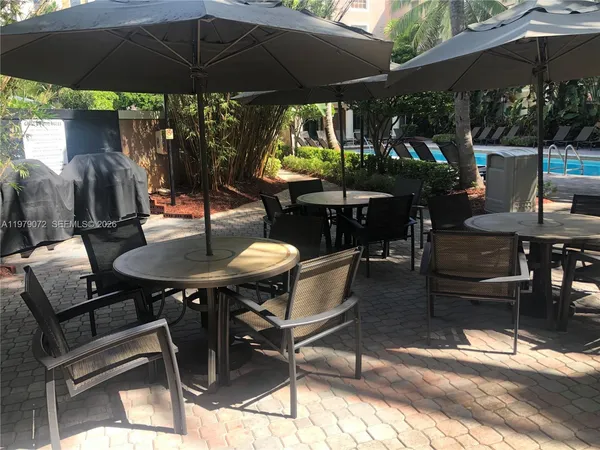 a patio with a table and chairs under an umbrella