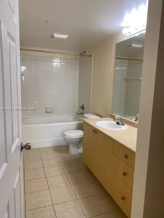 a spacious bathroom with a double vanity sink toilet mirror and bathtub