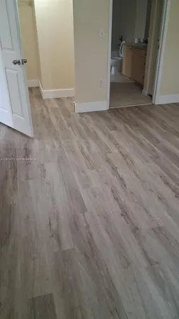 an empty room with wooden floor and white walls