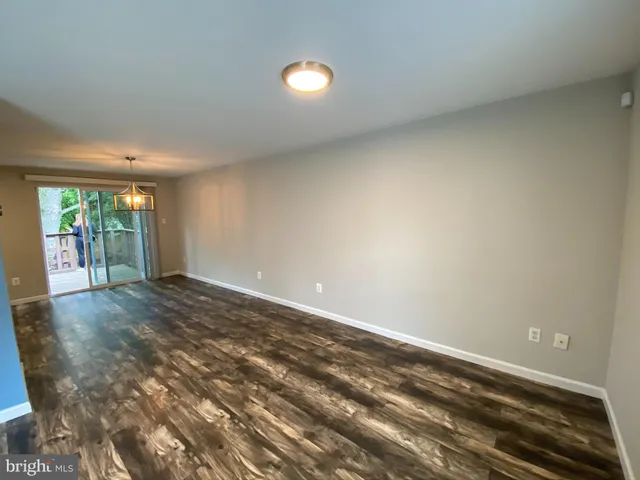 a view of empty room with wooden floor and windows