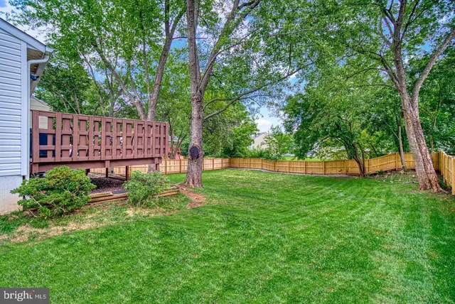 a view of a backyard with a garden and deck