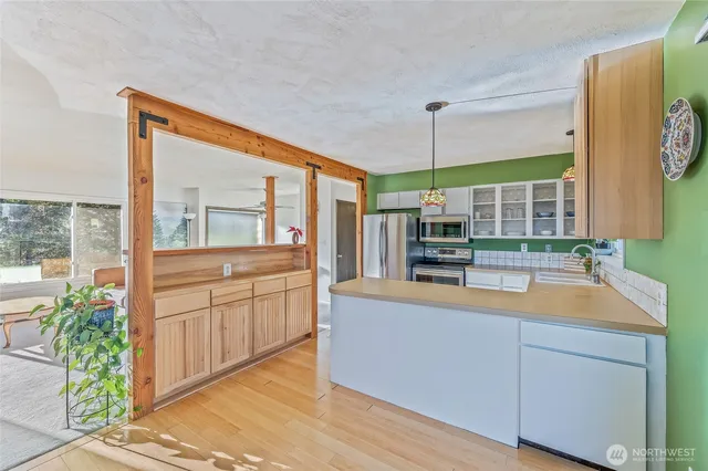 a large kitchen with kitchen island a large window in it