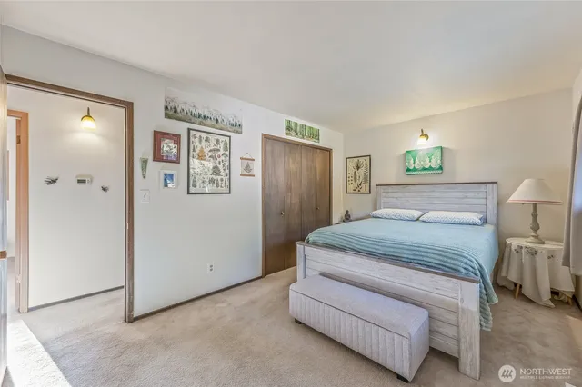 a bedroom with a bed and a painting on the wall