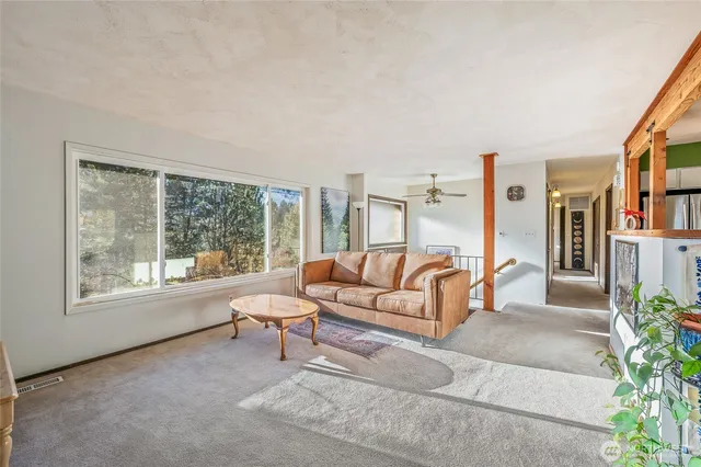 a living room with furniture and a potted plant next to a window