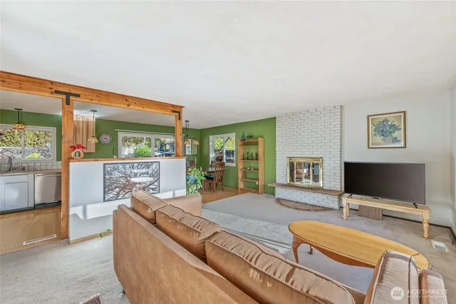a living room with furniture flat screen tv and a large window
