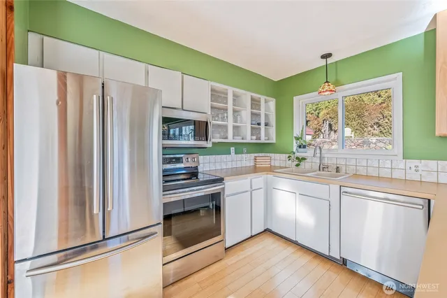 a kitchen with stainless steel appliances a stove sink and microwave