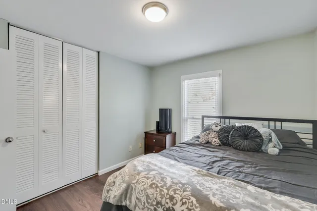 a bedroom with a bed and wooden floor