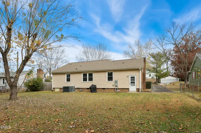a front view of house with yard and trees in the background