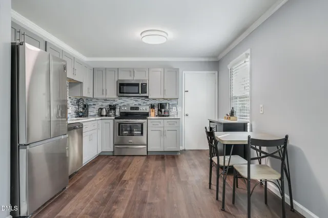 a kitchen with a table chairs refrigerator and a sink