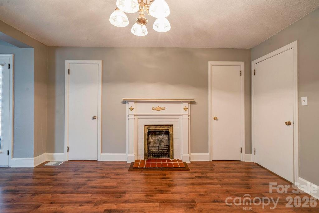 714 Linwood Road Kings Mountain, NC 28086 - Photo 12 of 26 a view of an empty room with wooden floor and a fireplace