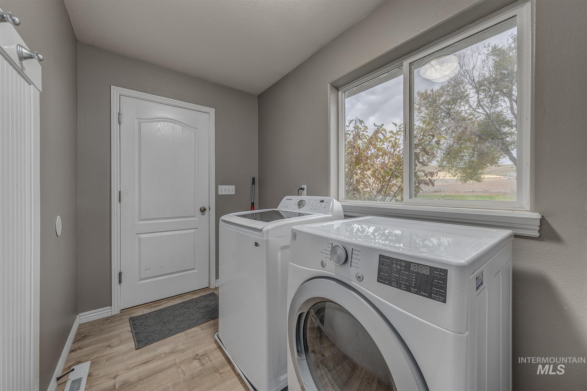 890 Jenkins Creek Road Weiser, ID 83672 - Photo 25 of 45 Laundry room featuring light wood finished floors and separate washer and dryer