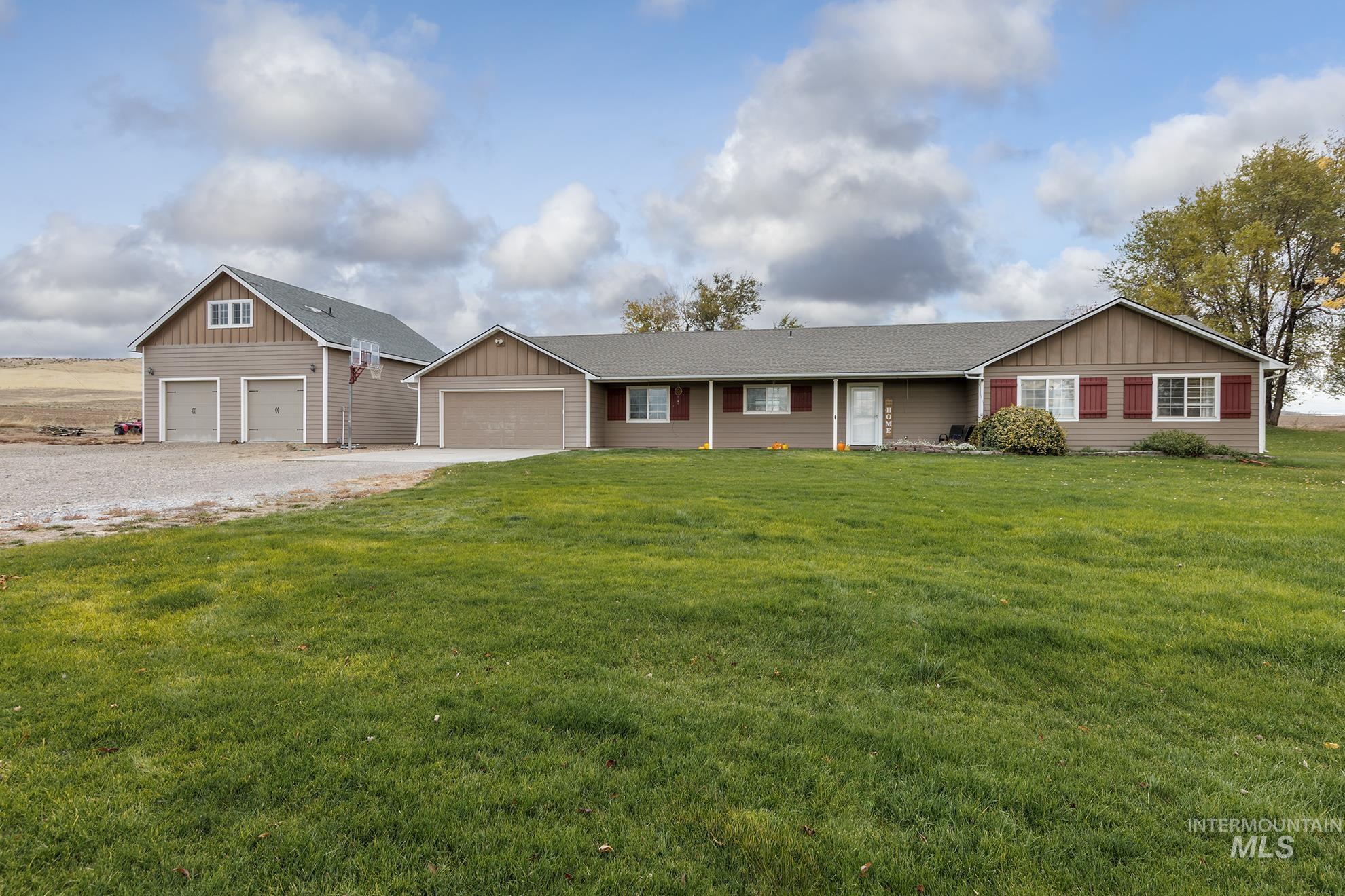 890 Jenkins Creek Road Weiser, ID 83672 - Photo 5 of 45 View of front of house with board and batten siding, a front yard, driveway, and a garage