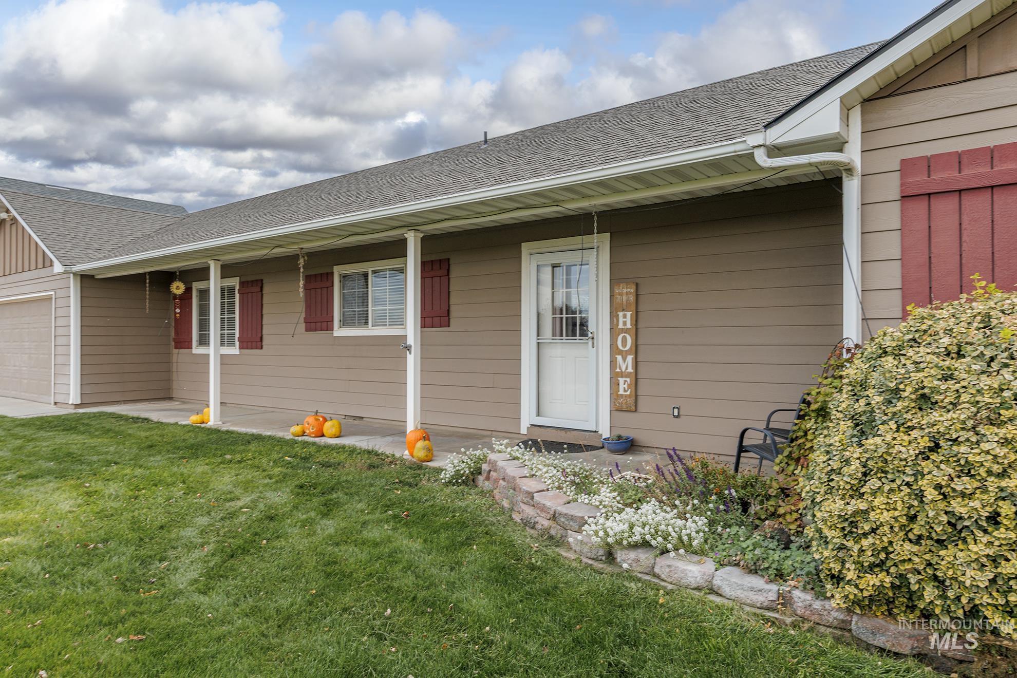 890 Jenkins Creek Road Weiser, ID 83672 - Photo 6 of 45 Entrance to property featuring roof with shingles, a yard, an attached garage, and a porch
