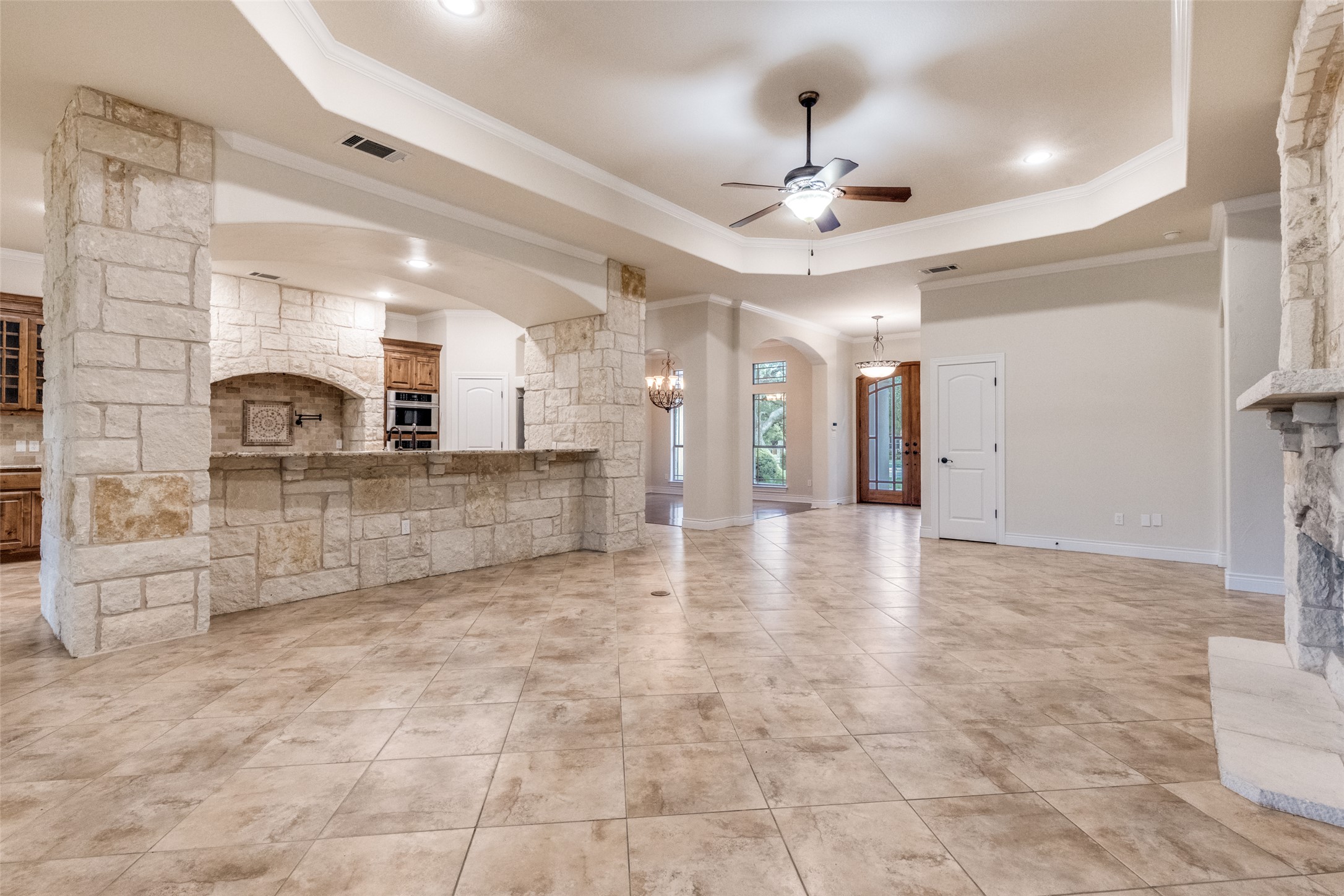 101 Copper Leaf Court Georgetown, TX 78633 - Photo 7 of 31 Spacious living area featuring stone-clad columns and a coordinating stone-faced breakfast bar