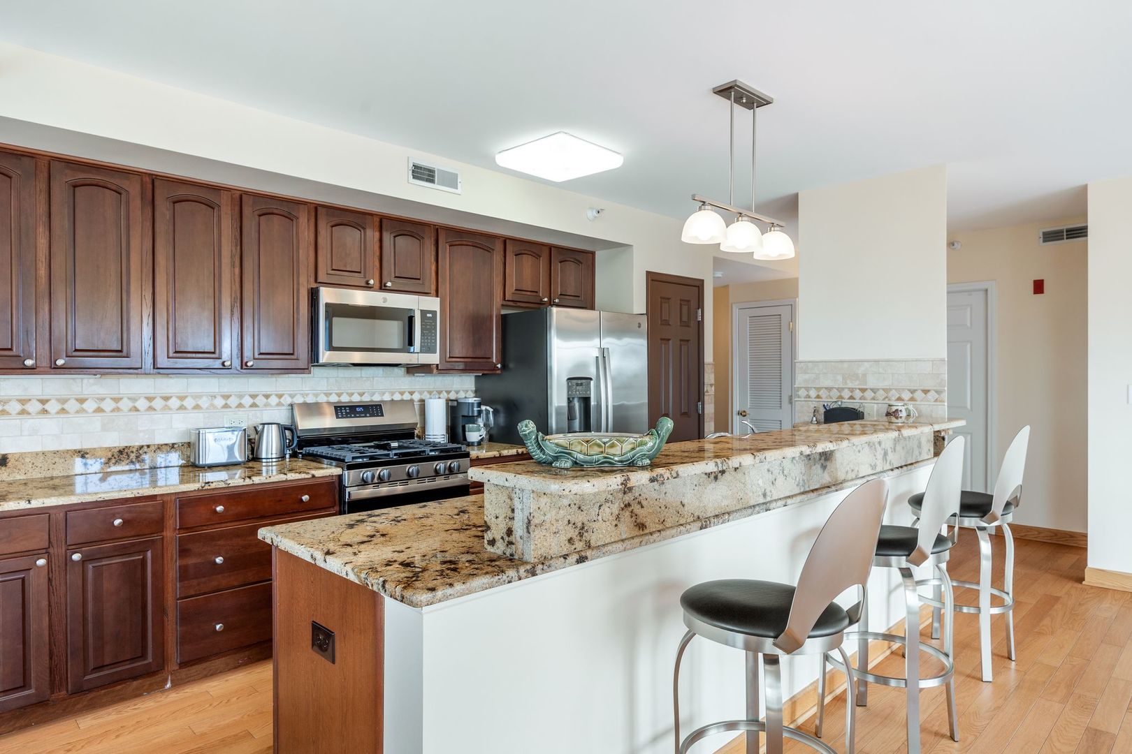 77 North Wolf Road, Unit 309 Northlake, IL 60164 - Photo 11 of 25 a kitchen with kitchen island granite countertop a sink and cabinets