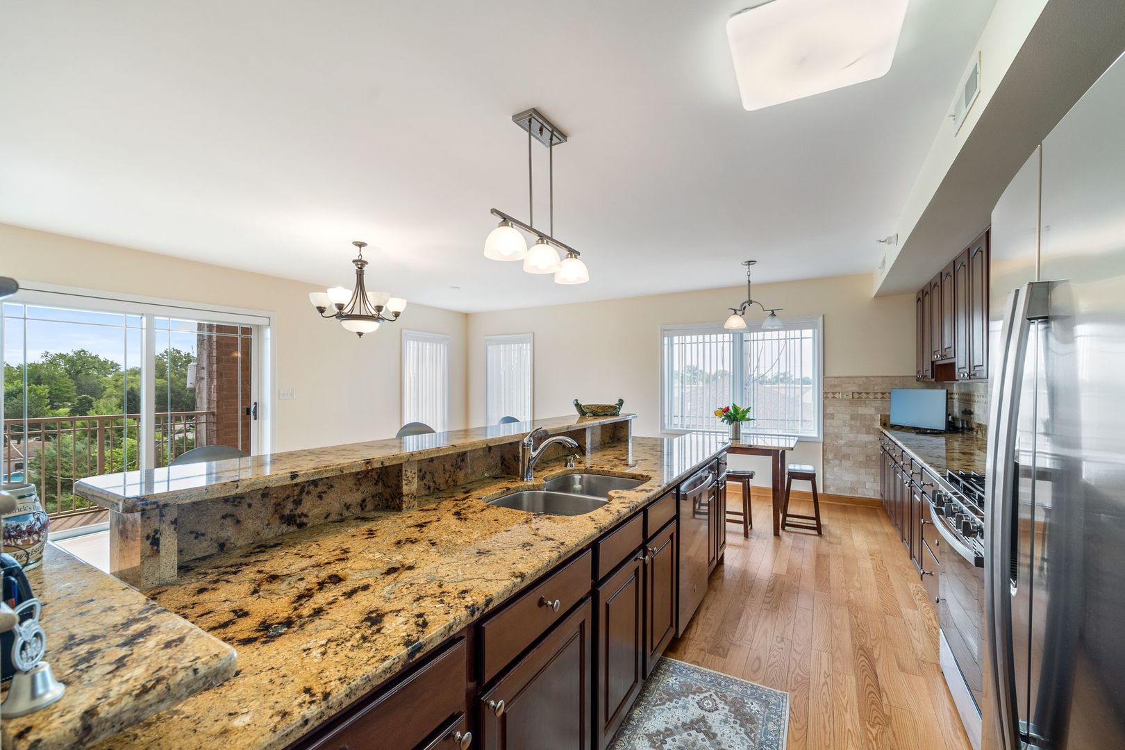 77 North Wolf Road, Unit 309 Northlake, IL 60164 - Photo 14 of 25 a large kitchen with kitchen island granite countertop a large window and stainless steel appliances