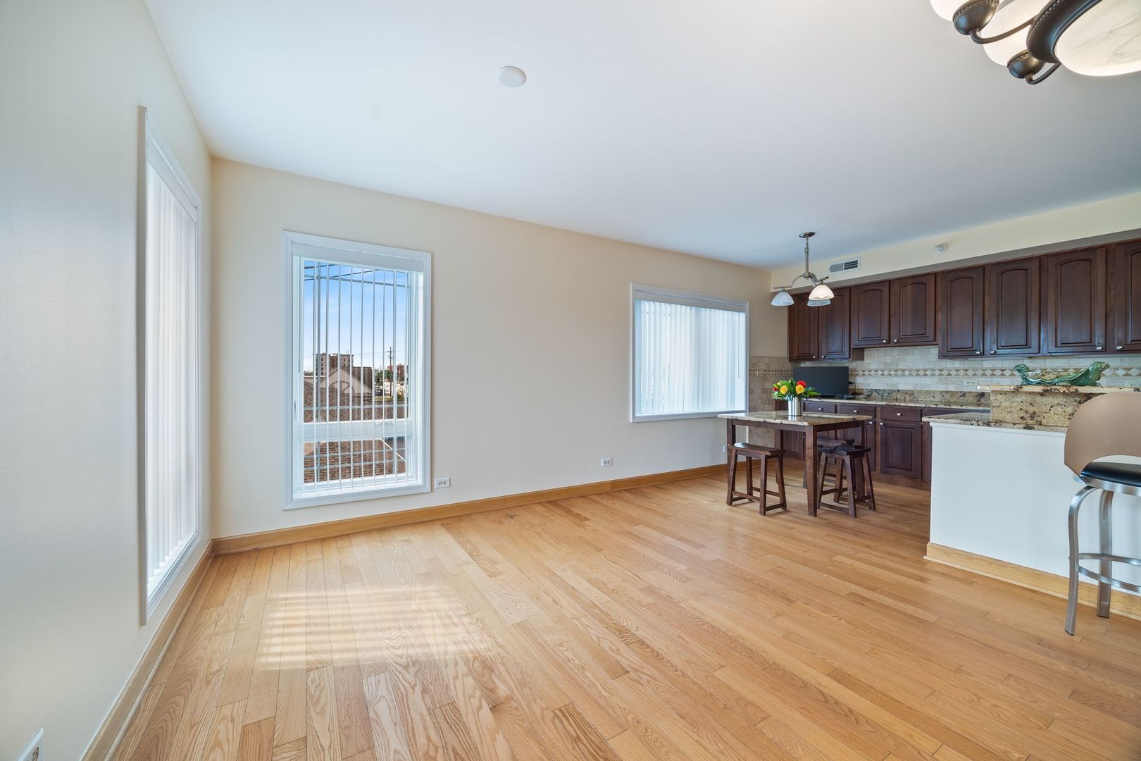 77 North Wolf Road, Unit 309 Northlake, IL 60164 - Photo 6 of 25 a view of kitchen with stainless steel appliances granite countertop a stove top oven a sink a dining table and chairs with wooden floor