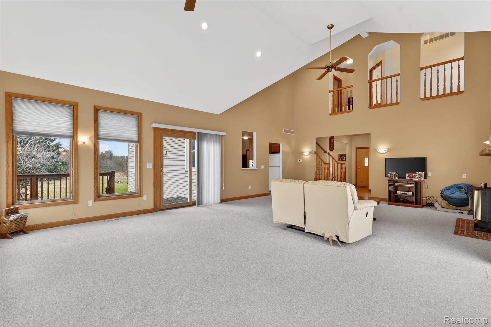 5640 Fisher Road Howell, MI 48855 - Photo 19 of 66 Living area featuring light colored carpet, ceiling fan, vaulted ceiling, and recessed lighting