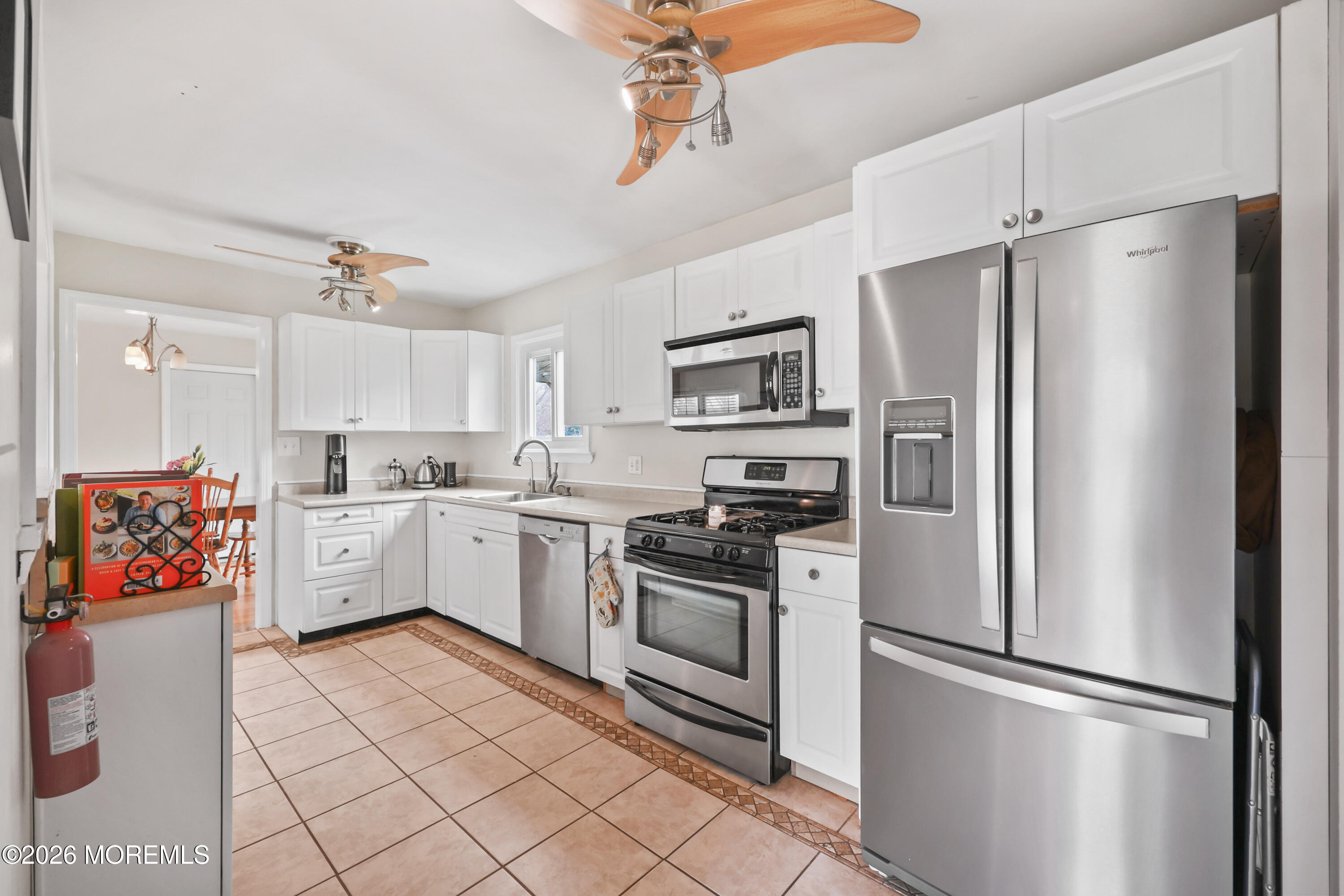 9 Maple Lane Howell, NJ 07731 - Photo 14 of 32 a kitchen with white cabinets stainless steel appliances and a refrigerator
