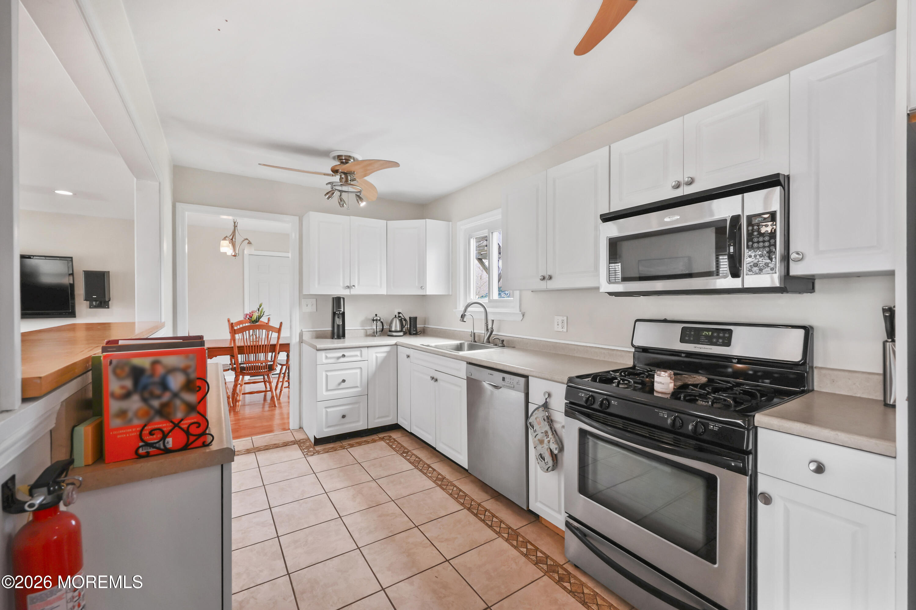 9 Maple Lane Howell, NJ 07731 - Photo 15 of 32 a kitchen with stainless steel appliances a stove microwave and cabinets