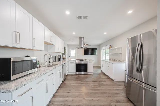 a dining room with wooden floor a chandelier a wooden table and chairs
