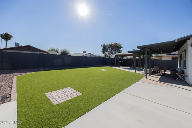 a view of a house with a backyard and a patio
