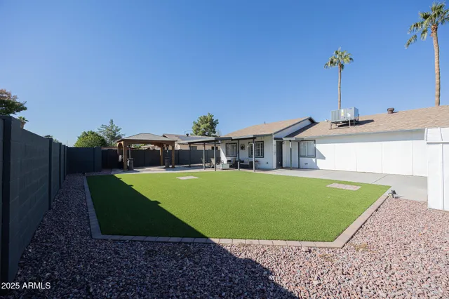 a view of a house with a yard and sitting area