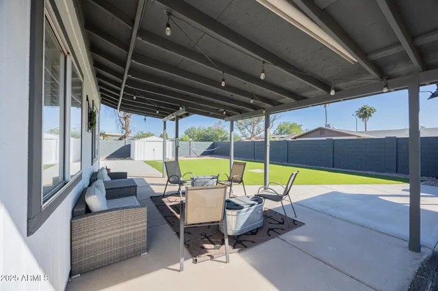 a view of a patio with table and chairs next to a yard