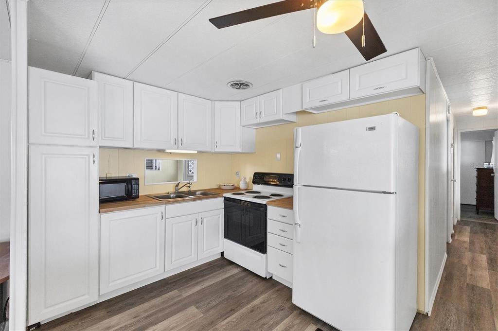 4114 10th St Court East Ellenton, FL 34222 - Photo 12 of 44 a kitchen with white cabinets and white appliances