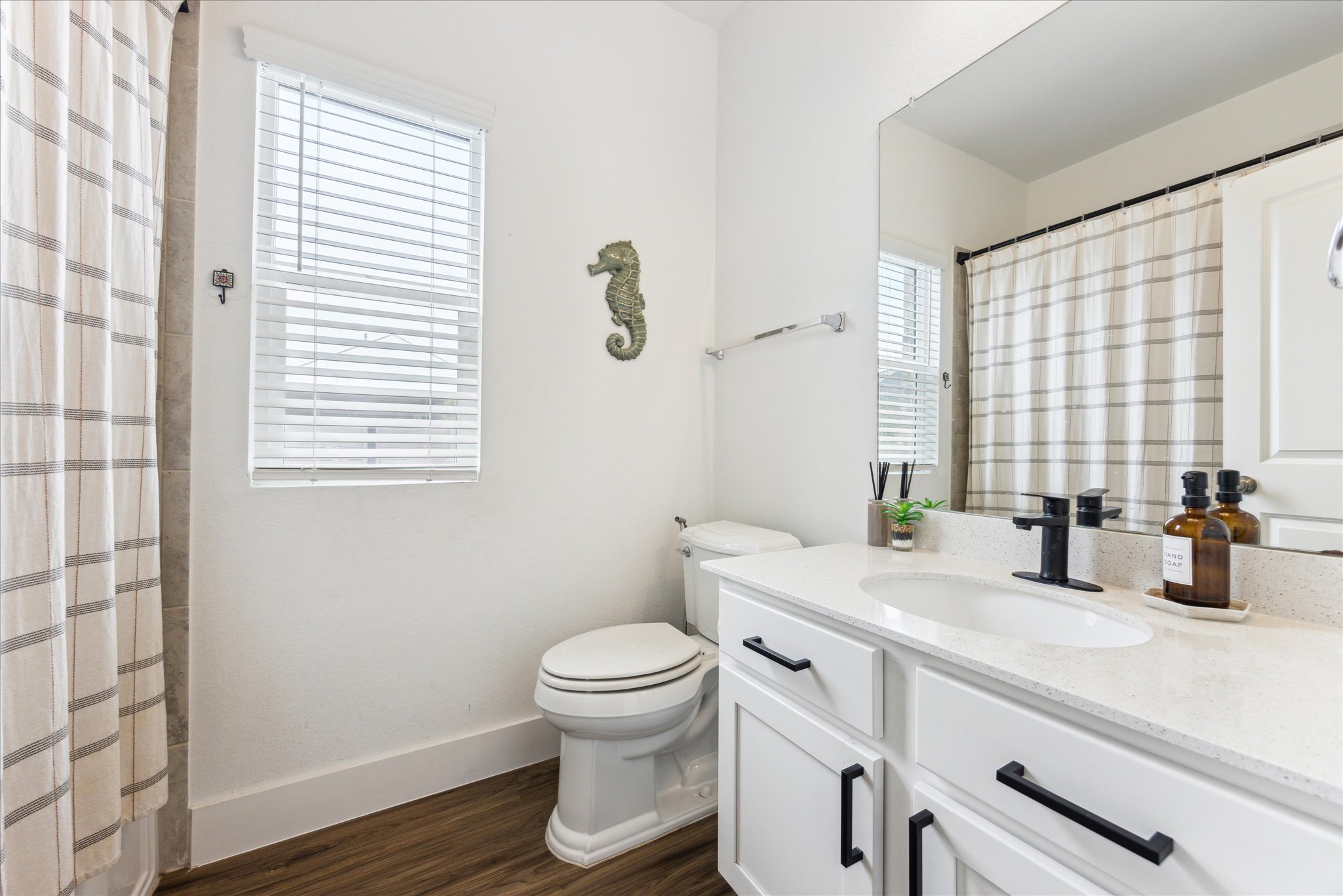 700 Legends Lane Georgetown, TX 78628 - Photo 22 of 31 Bathroom featuring toilet, vanity, wood finished floors, baseboards, and curtained shower