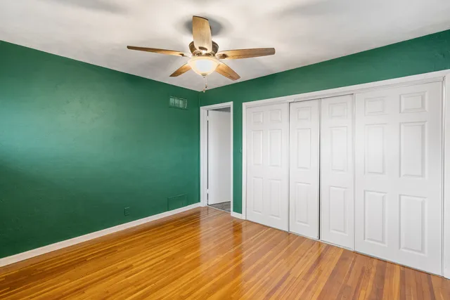a view of a room with a ceiling fan and wooden floor