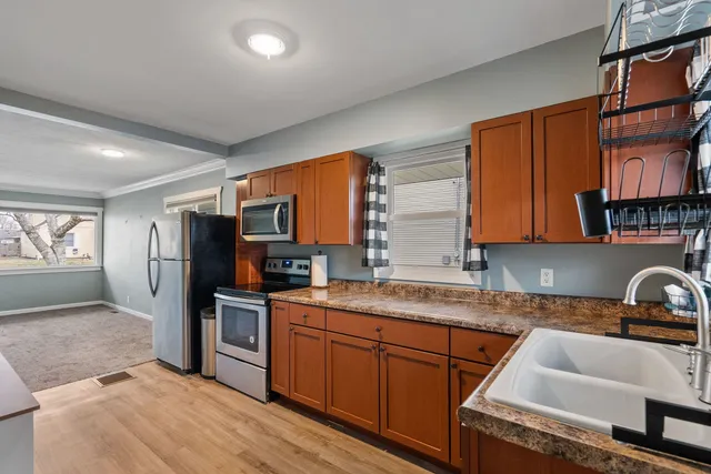 a kitchen with granite countertop a sink stainless steel appliances and cabinets
