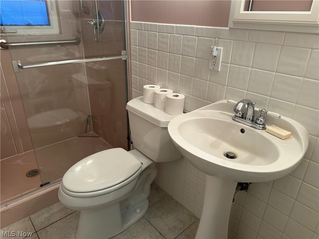 3192 Mogadore Road Akron, OH 44312 - Photo 24 of 43 First Floor Bathroom with tile walls, a stall shower, and light tile patterned floors