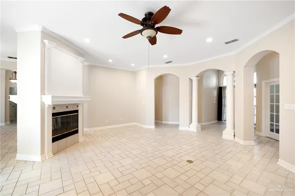 a view of a livingroom with a fireplace a ceiling fan and windows