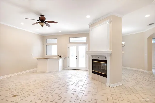 a view of an empty room with window and chandelier