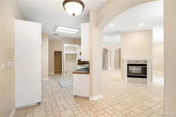 an empty room with wooden floor chandelier and window