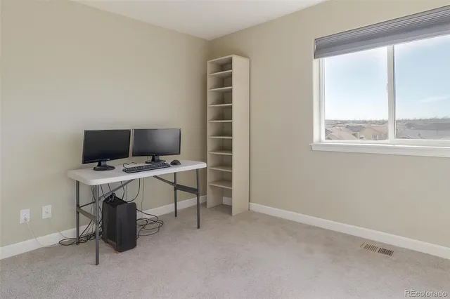 a view of a workspace with furniture and a window