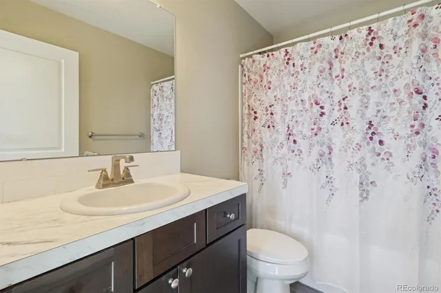 a bathroom with a sink toilet and a mirror
