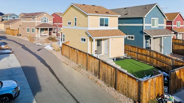a view of a big house with wooden fence