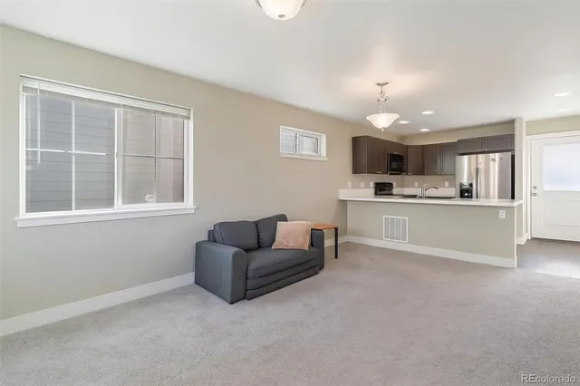 a living room with furniture and kitchen